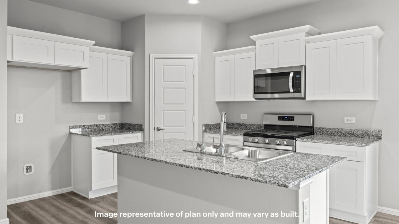 Bright kitchen with white cabinetry, granite countertops, and large island.