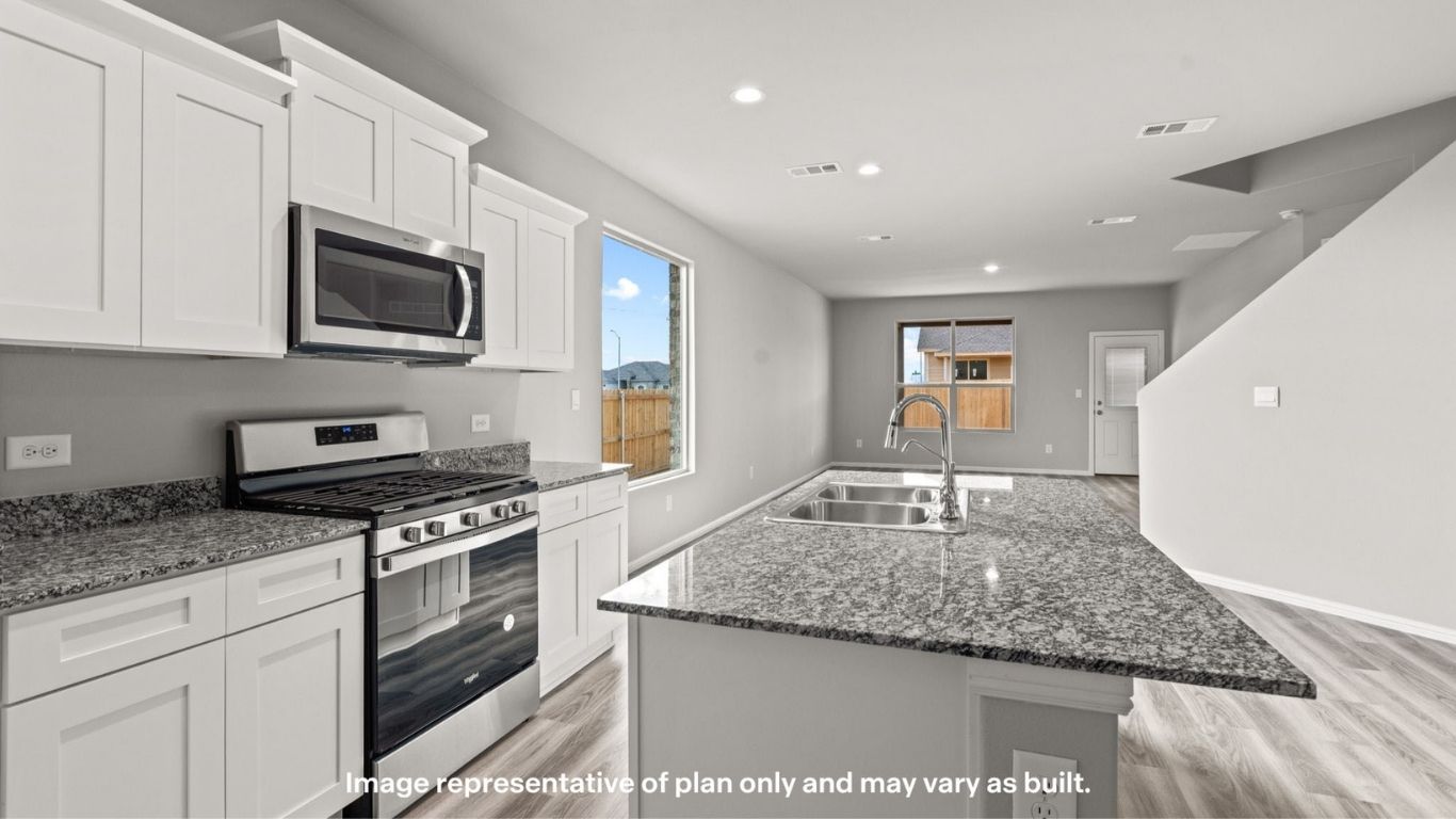 Open-concept kitchen with stainless steel appliances and spacious layout.