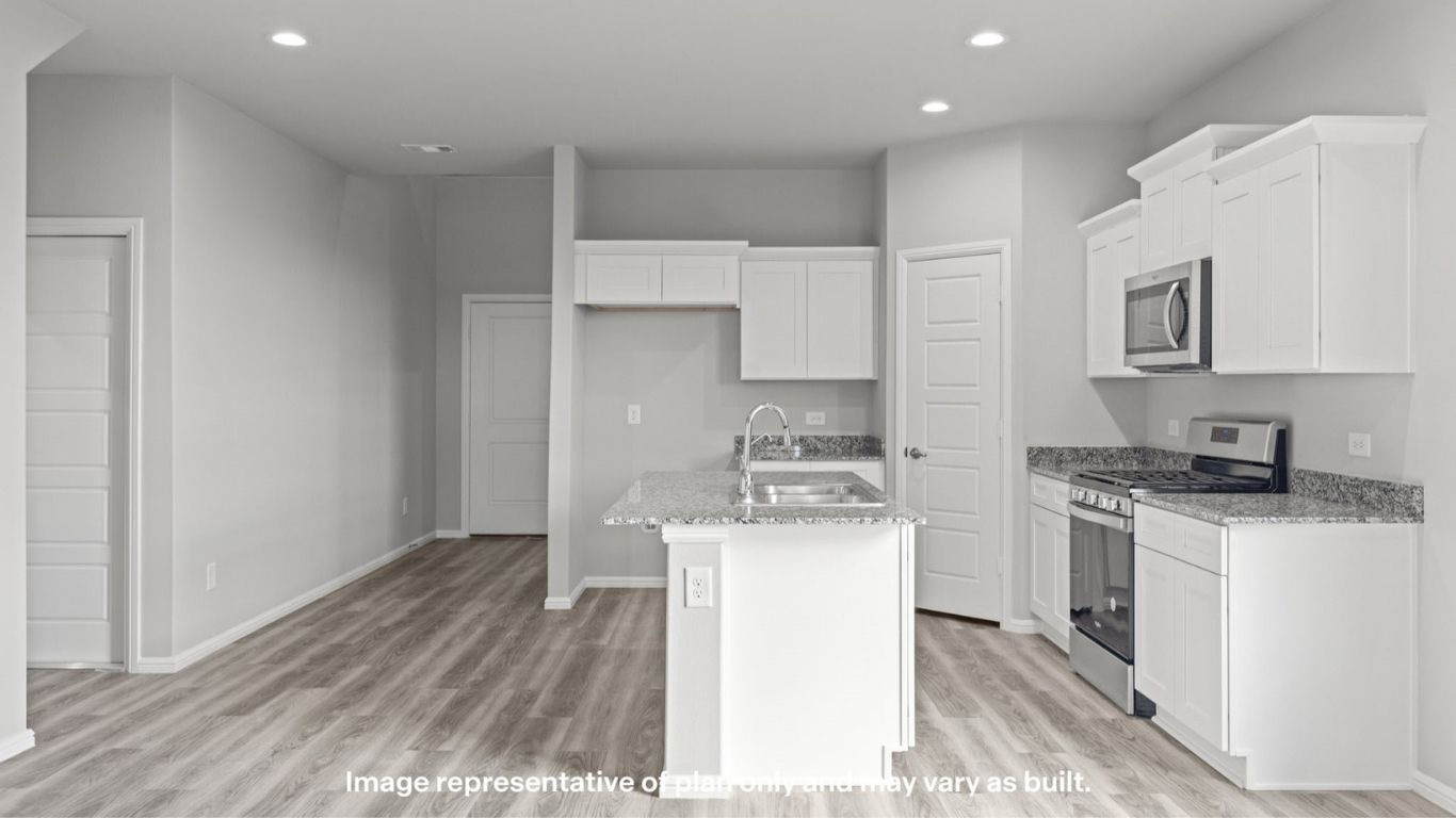 Wide view of kitchen and living space with seamless open flow.