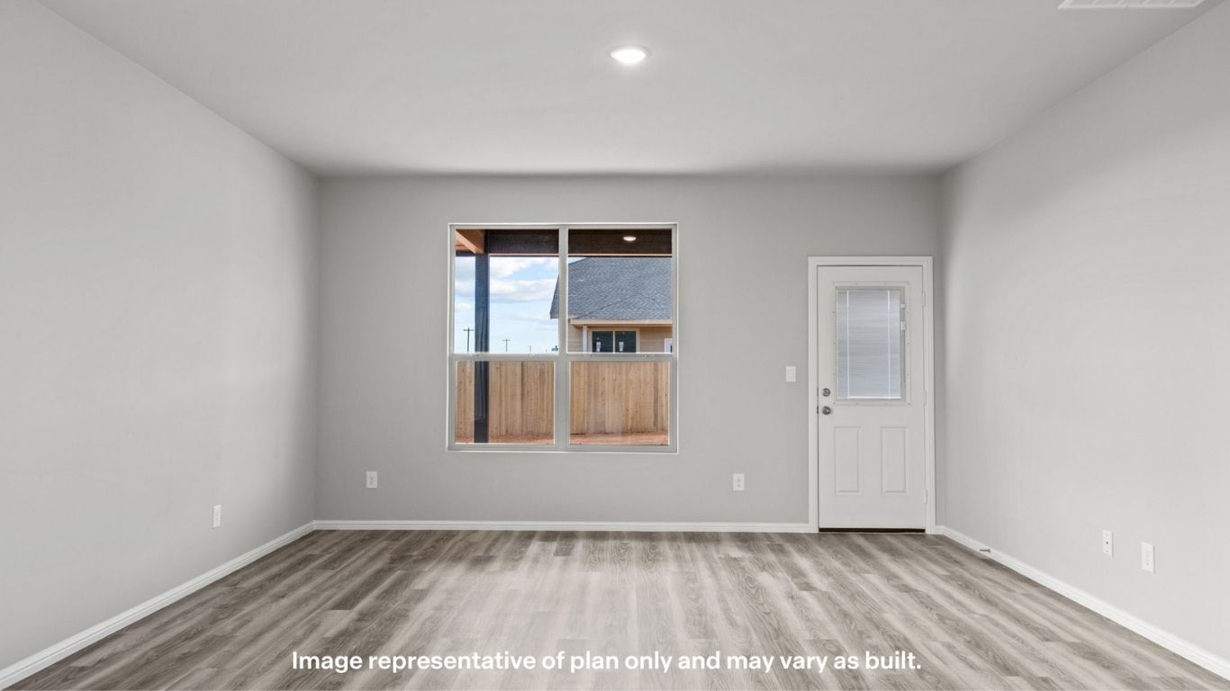 Spacious living area with large window and backyard access.