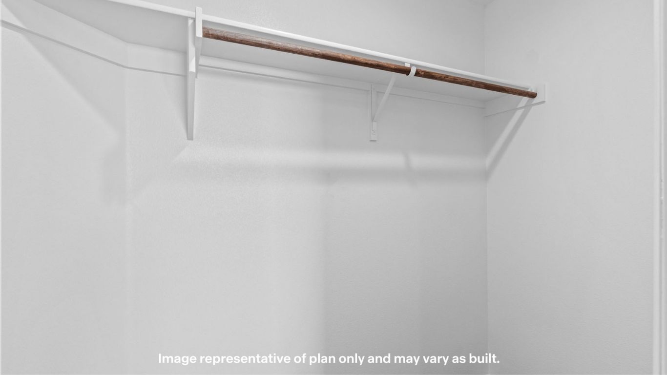 Walk-in closet with built-in shelving and hanging space for storage.