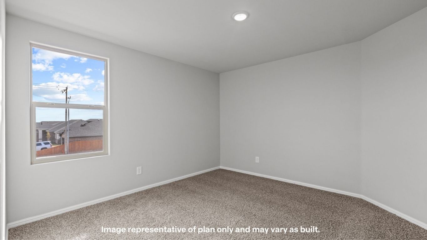 Bright bedroom featuring large window and soft carpeting.