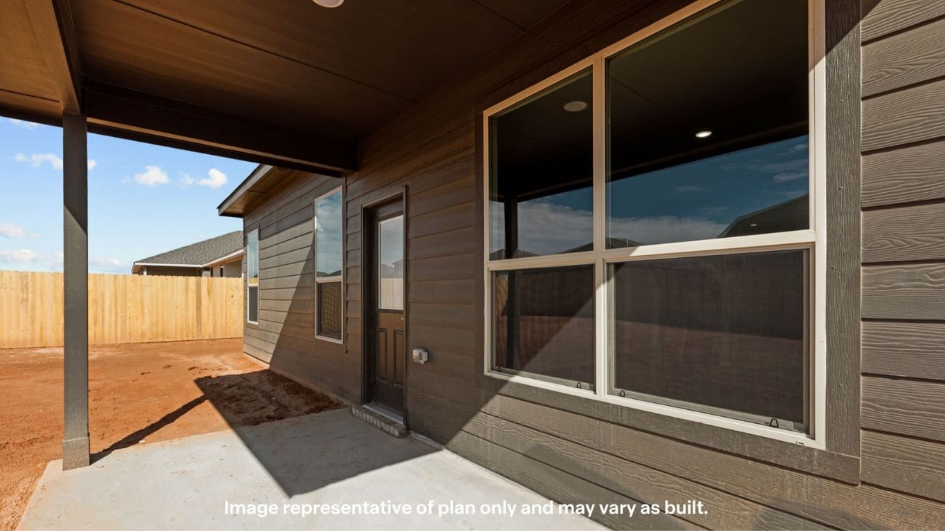 Covered back patio with concrete slab, siding detail, and fenced backyard.