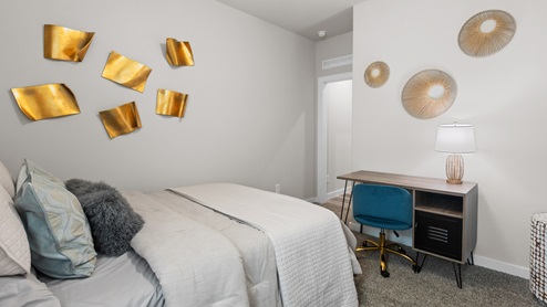Bedroom two space with desk, queen bed, ample closet space, and side facing window