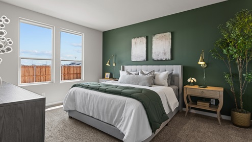 Primary bedroom with spacious windows overlooking backyard and allowing for plenty of natural sunlight