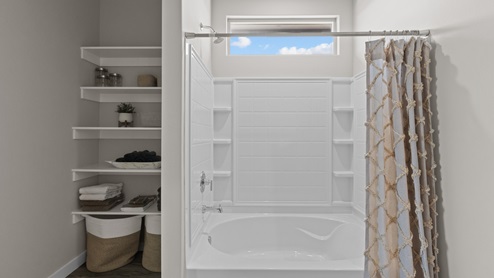 Primary bathroom shower and bathtub with built in shelving for storage