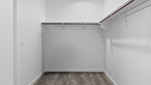 Primary bedroom walk-in closet with ample shelving and hanging space
