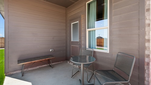 Covered back patio overlooking spacious backyard with room for entertaining