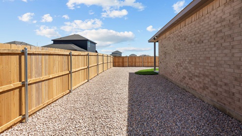 Spacious side yard with privacy fence and rock hardscaping