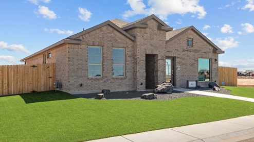 Exterior side view of single-story modern brick Cali floor plan home on spacious corner lot