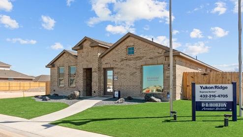 Exterior side view of single-story Cali floor plan classic brick home with green turf and hardscaping
