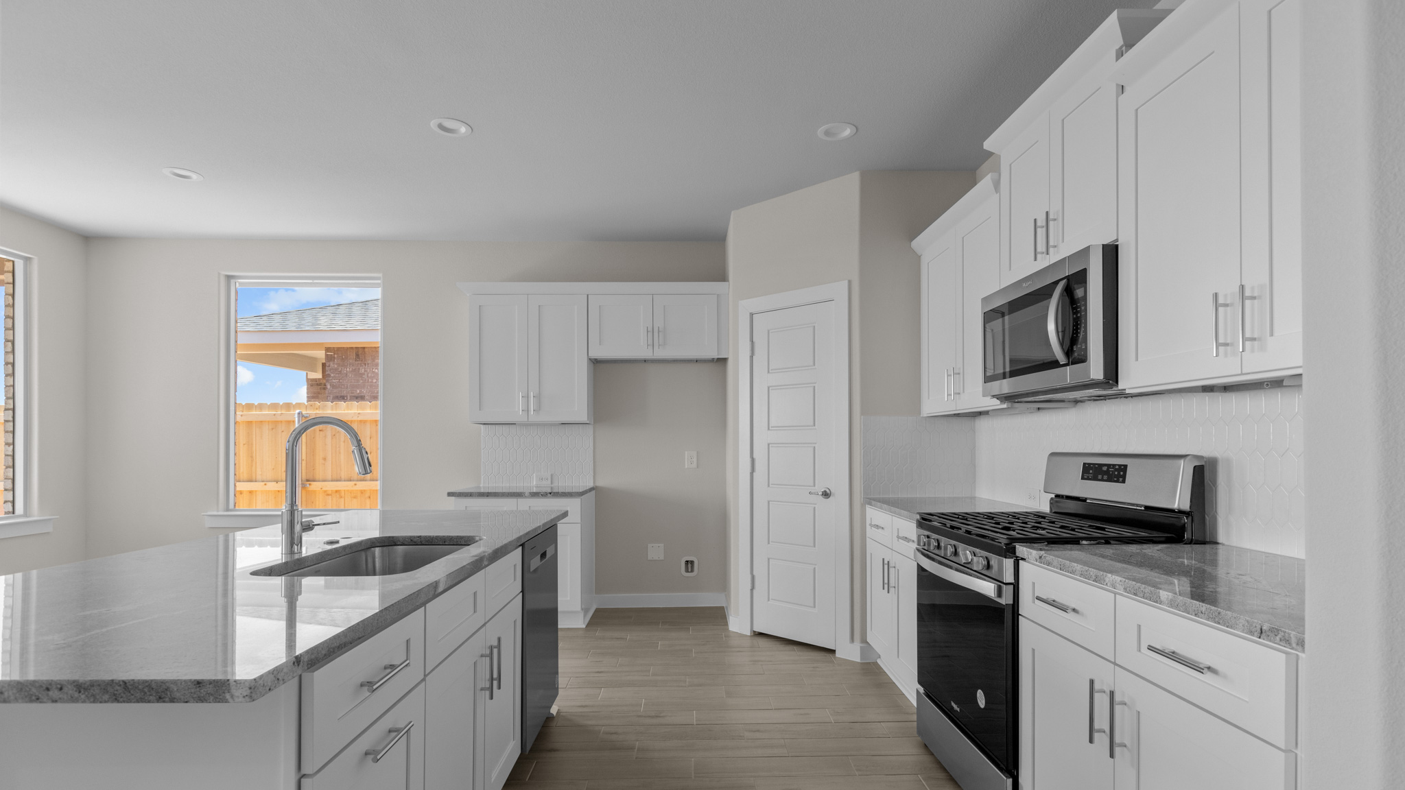 Kitchen area with your choice of granite or quartz countertops, stylish backsplash, and complete with stainless steel appliances
