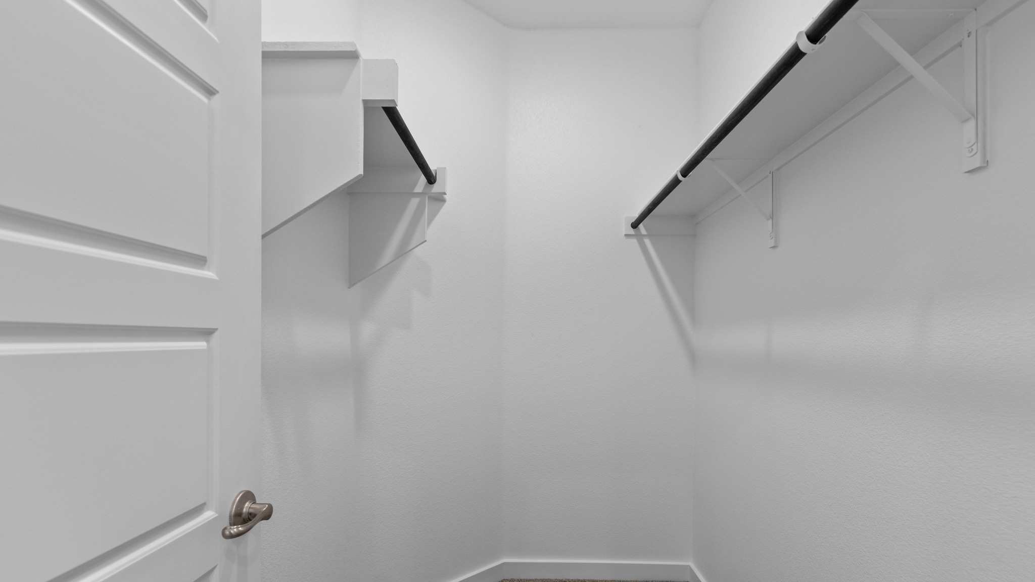 Primary bedroom walk-in closet attached to primary bathroom