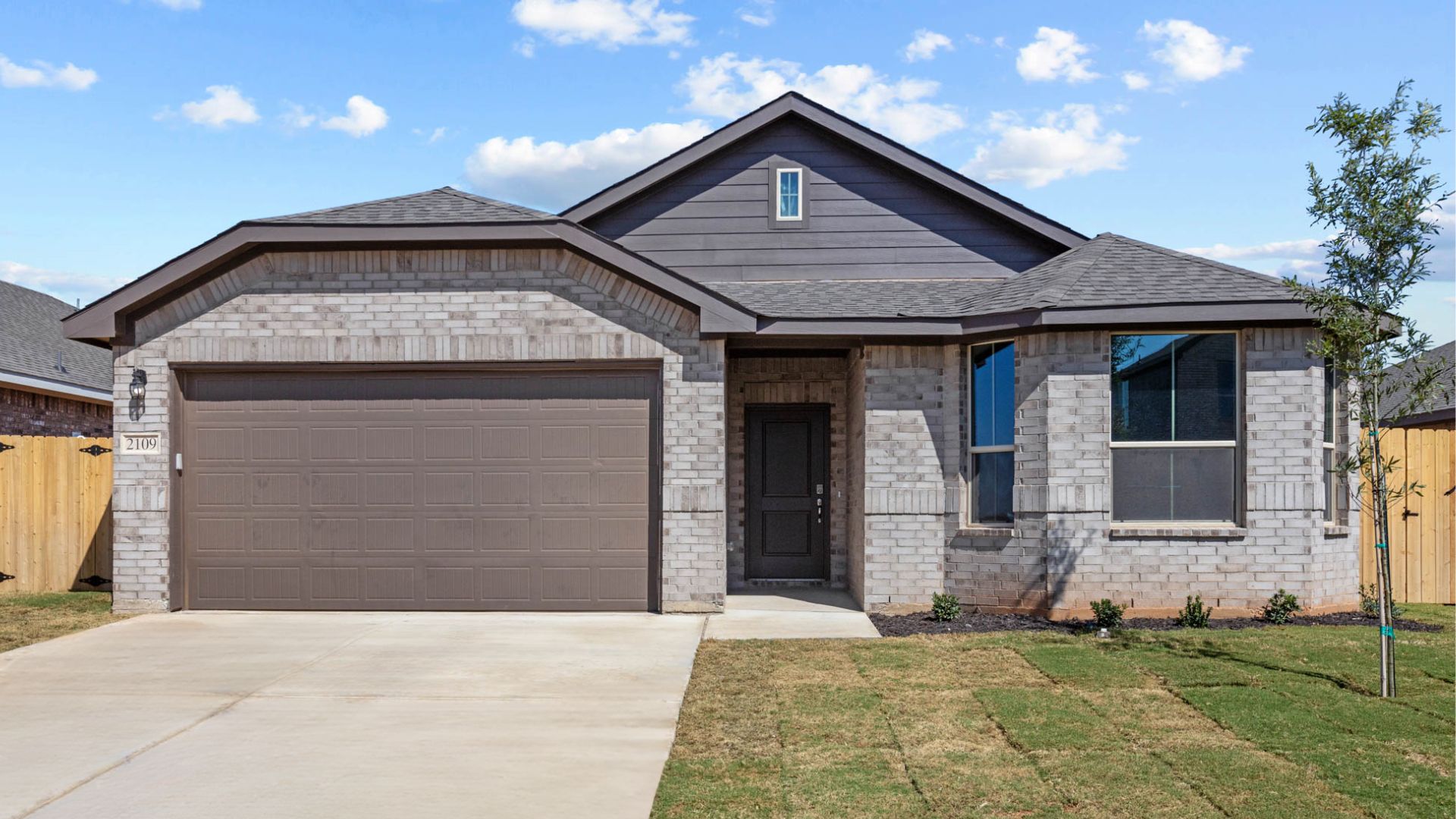 Exterior of single-story modern brick home with unique pitched roof