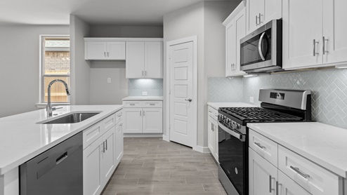 Open concept spacious kitchen area with stainless steel appliances and stylish backsplash