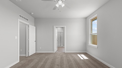 Spacious primary bedroom with plush carpeted floors
