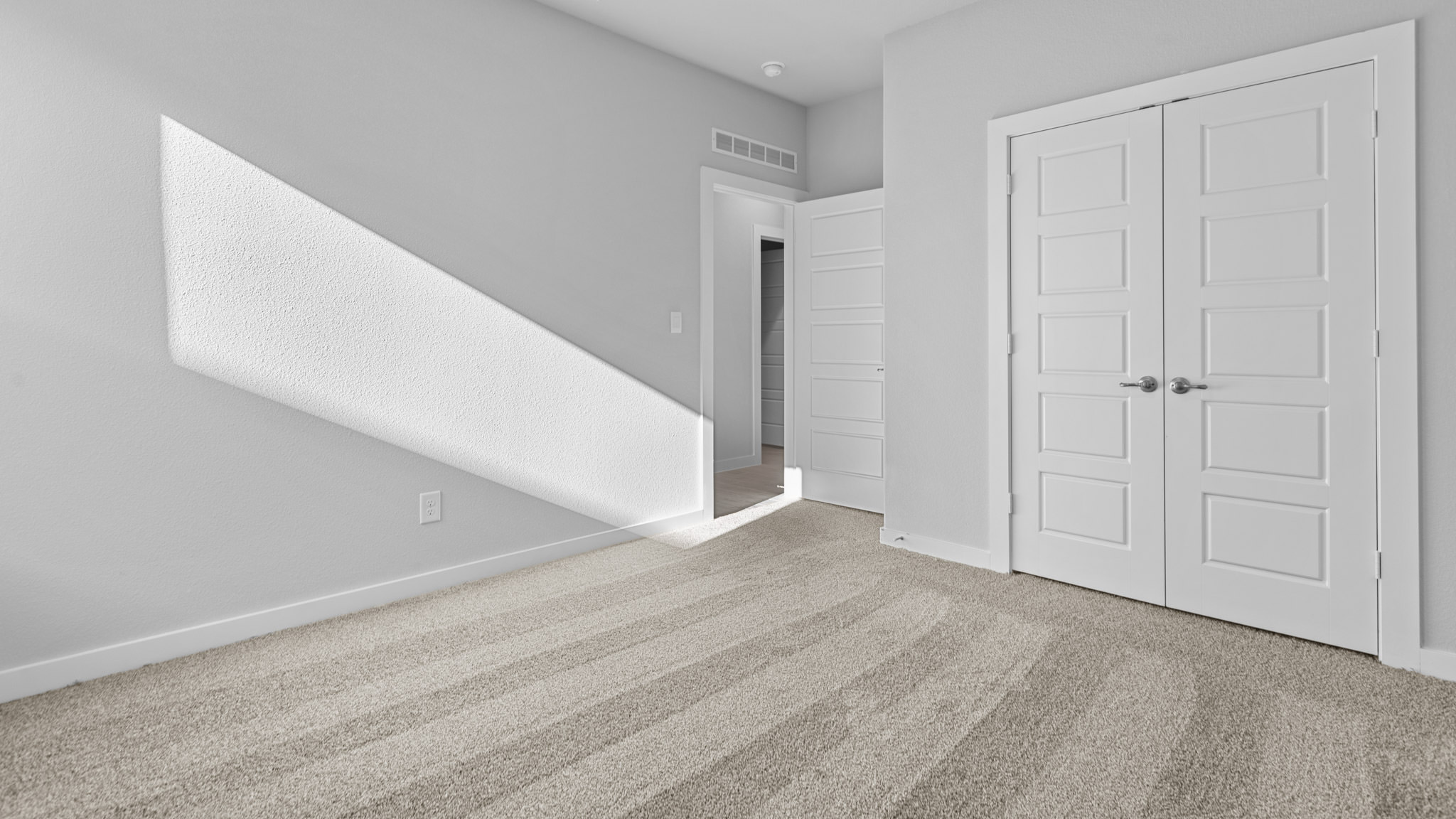 Guest bedroom 2 with side window and plush carpet floor