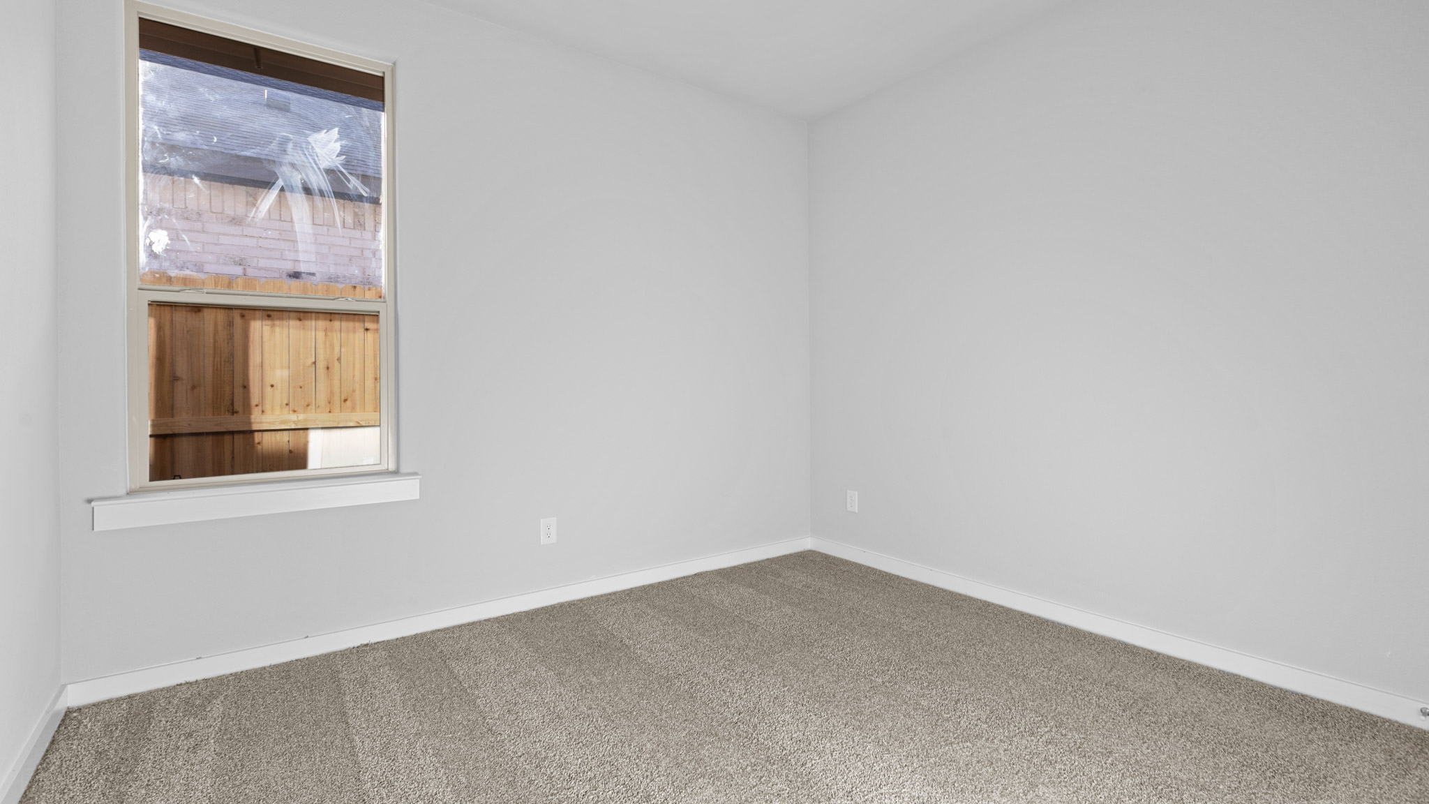 Guest bedroom 2 with side window and plush carpet floor