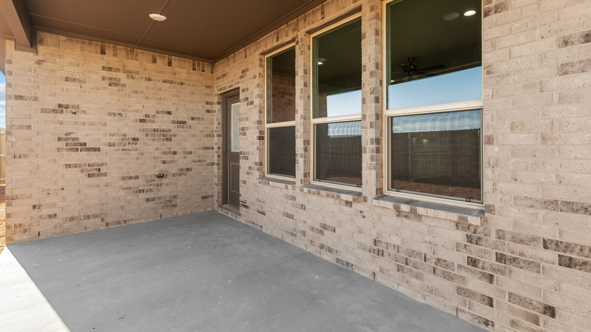 Covered back patio area overlooking spacious backyard