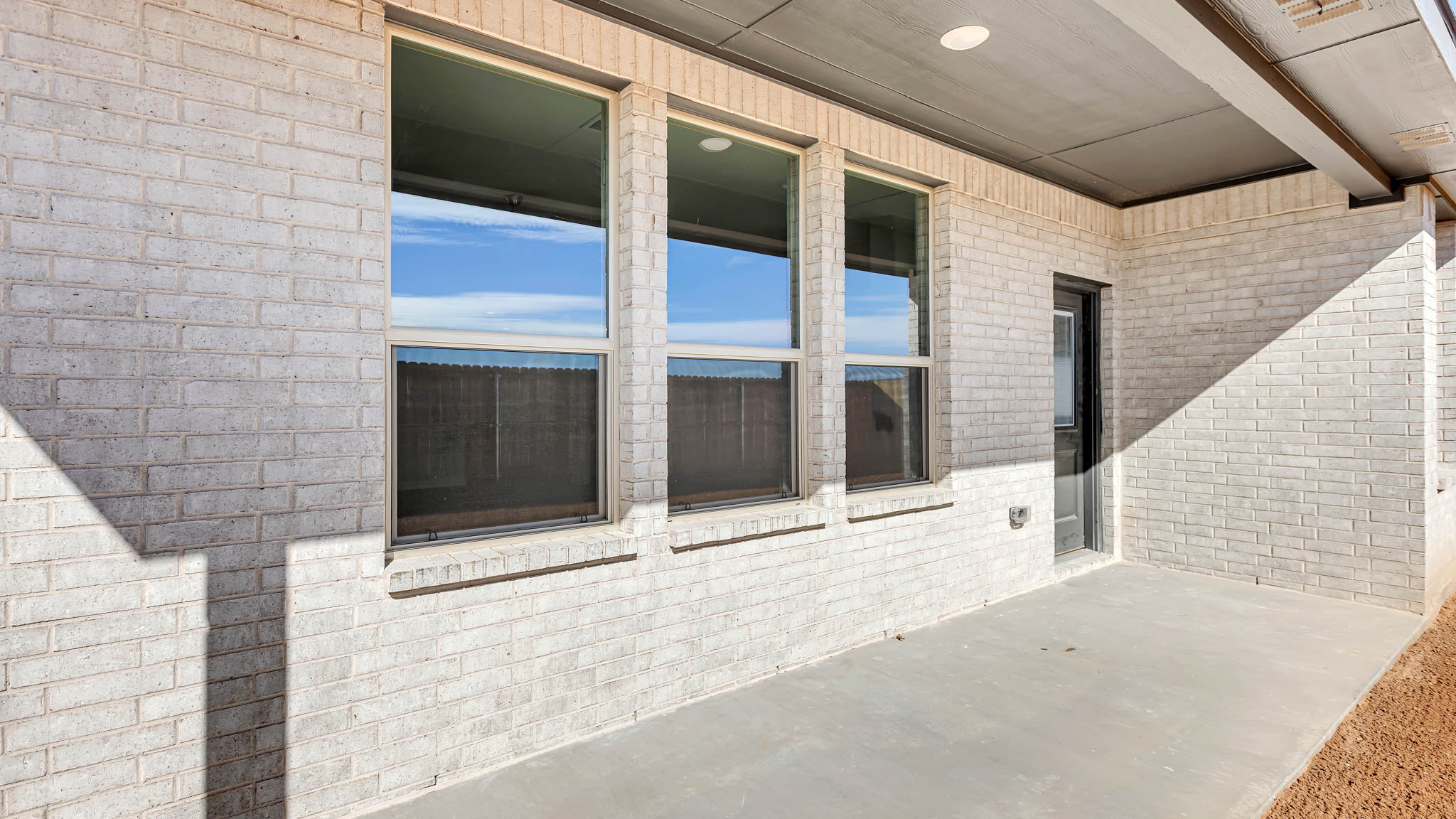 Covered back patio area overlooking spacious backyard
