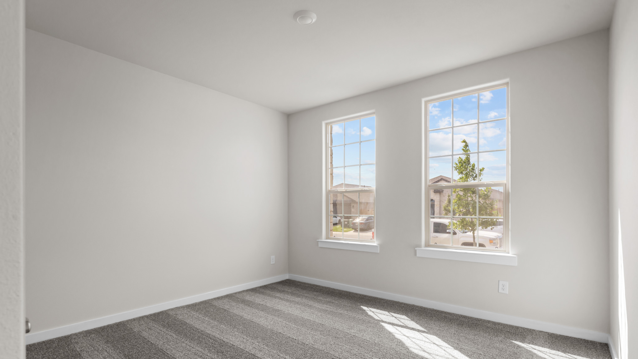 Guest bedroom 1 with front windows and ample natural light