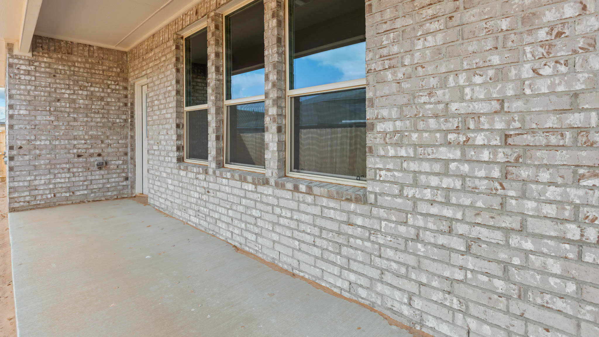 Covered back patio area overlooking spacious backyard
