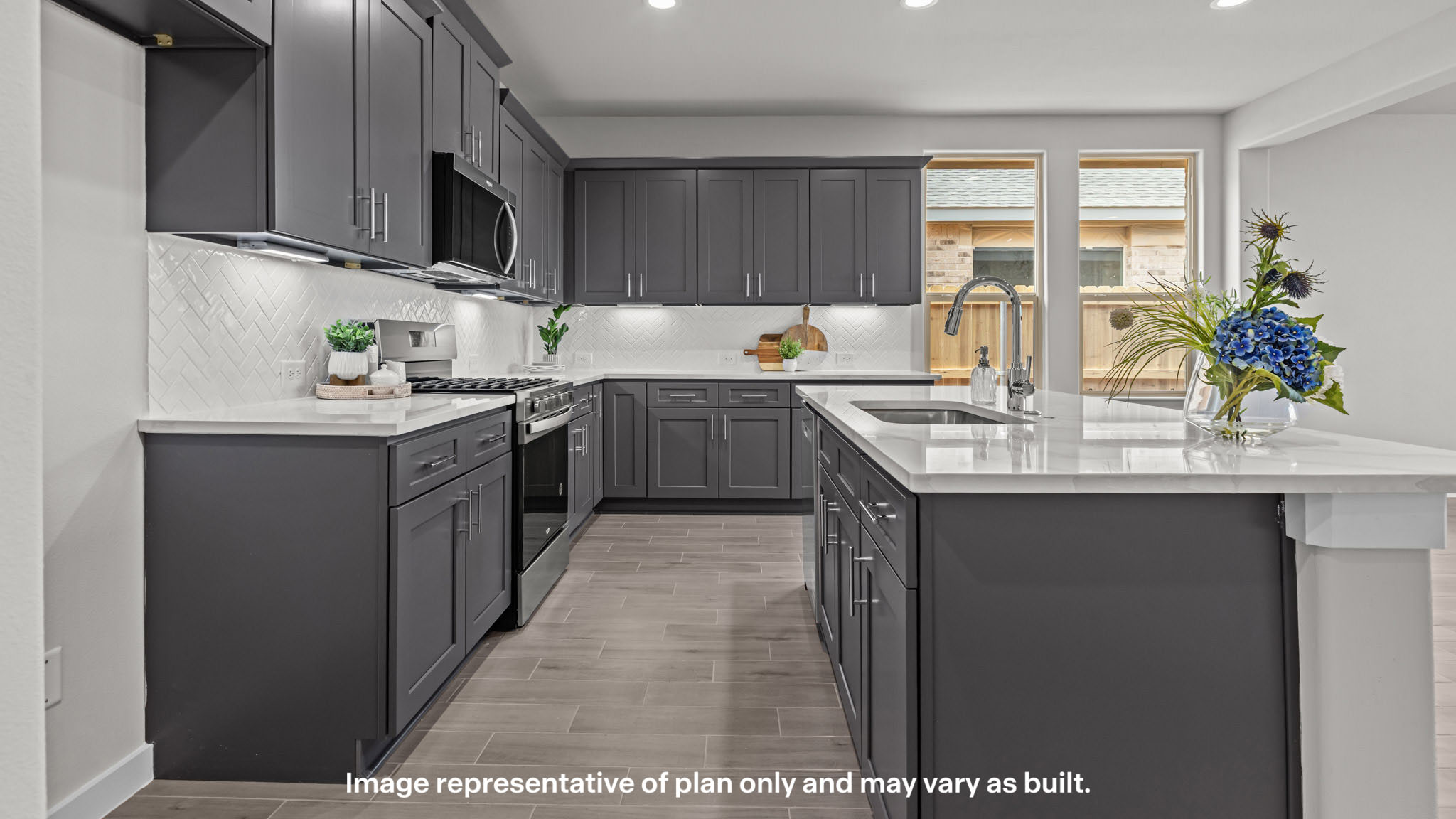 Open concept kitchen with stainless steel appliances, shaker style cabinets, and elevated finishes