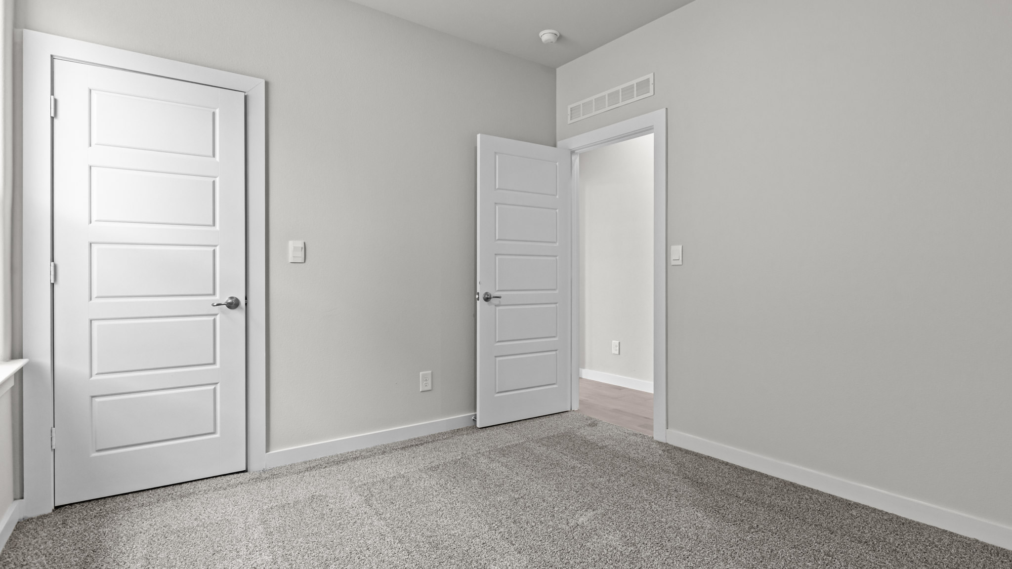 Guest bedroom 2 with side window and plush carpet floor