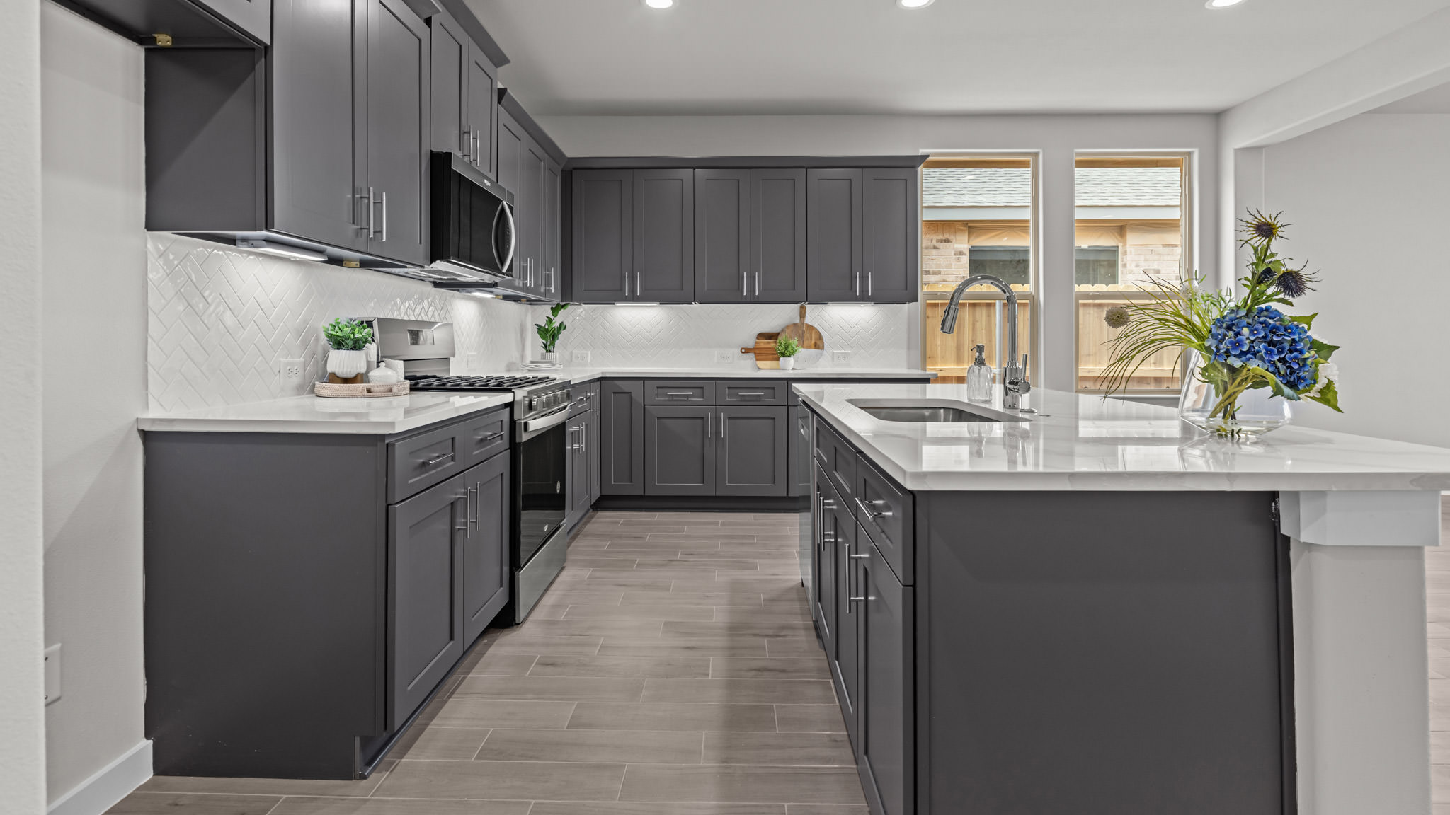 Open concept kitchen with stainless steel appliances, shaker style cabinets, and elevated finishes