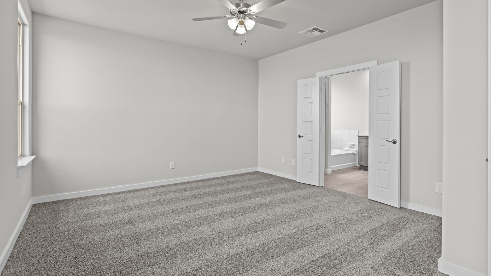 Primary bedroom with private attached bathroom and walk-in closet