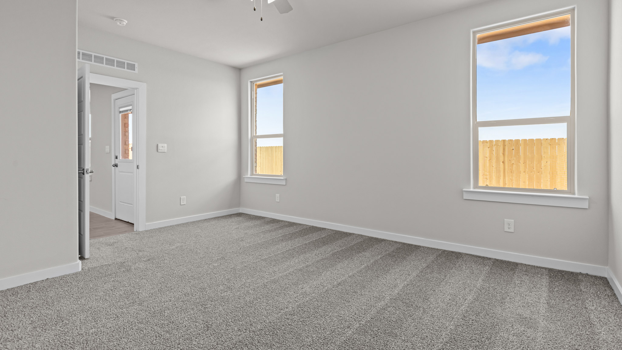 Primary bedroom with plush carpet floors and light allowing double windows