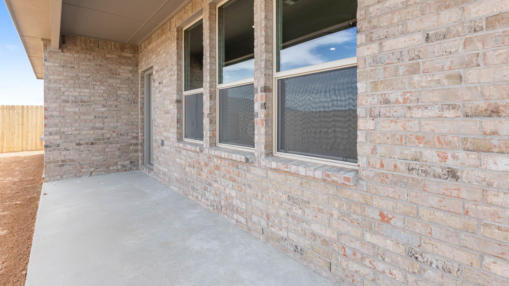 Covered back patio area overlooking spacious backyard