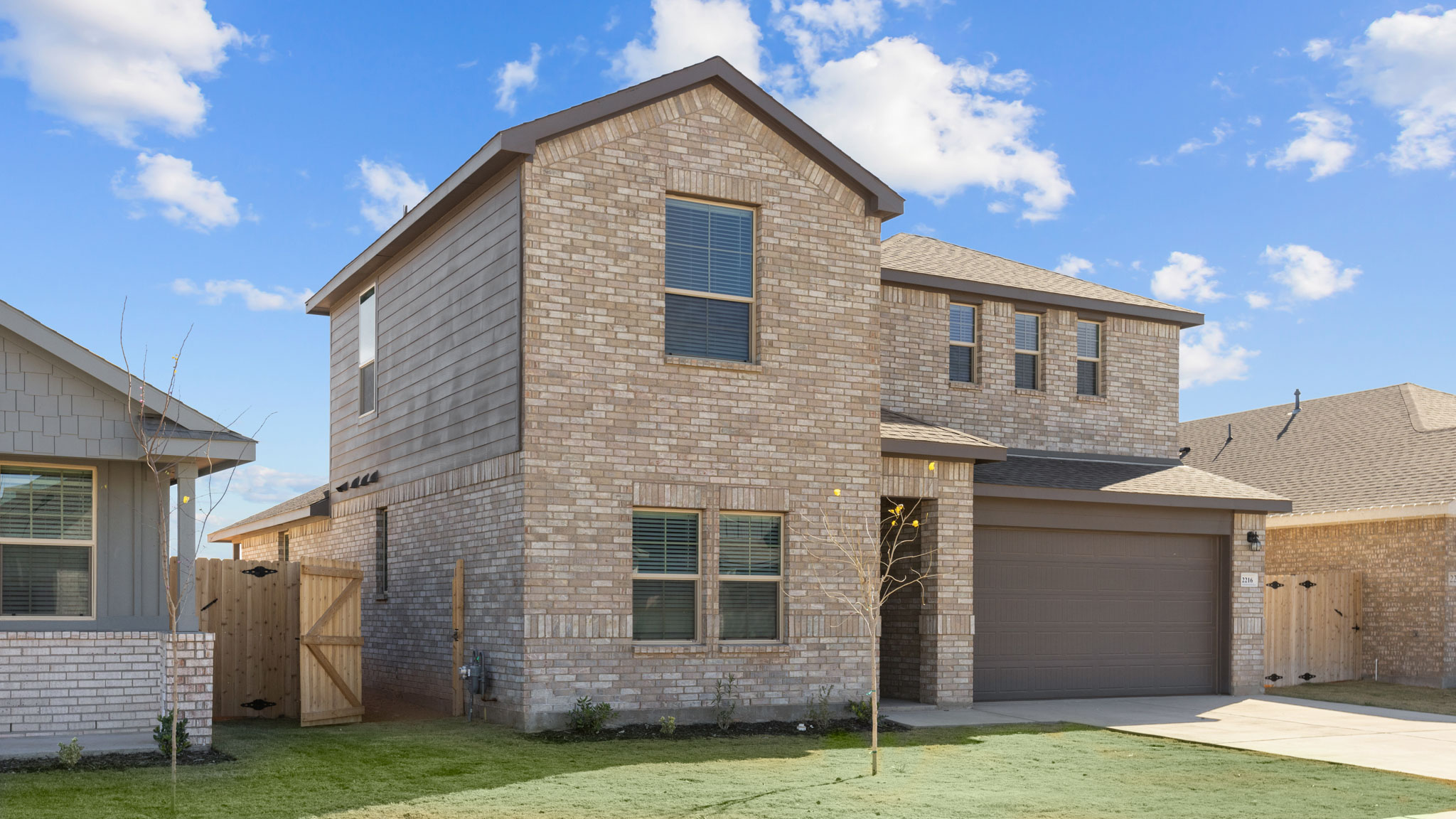 Exterior side view of timeless brick two story home with modern sturdy siding accents