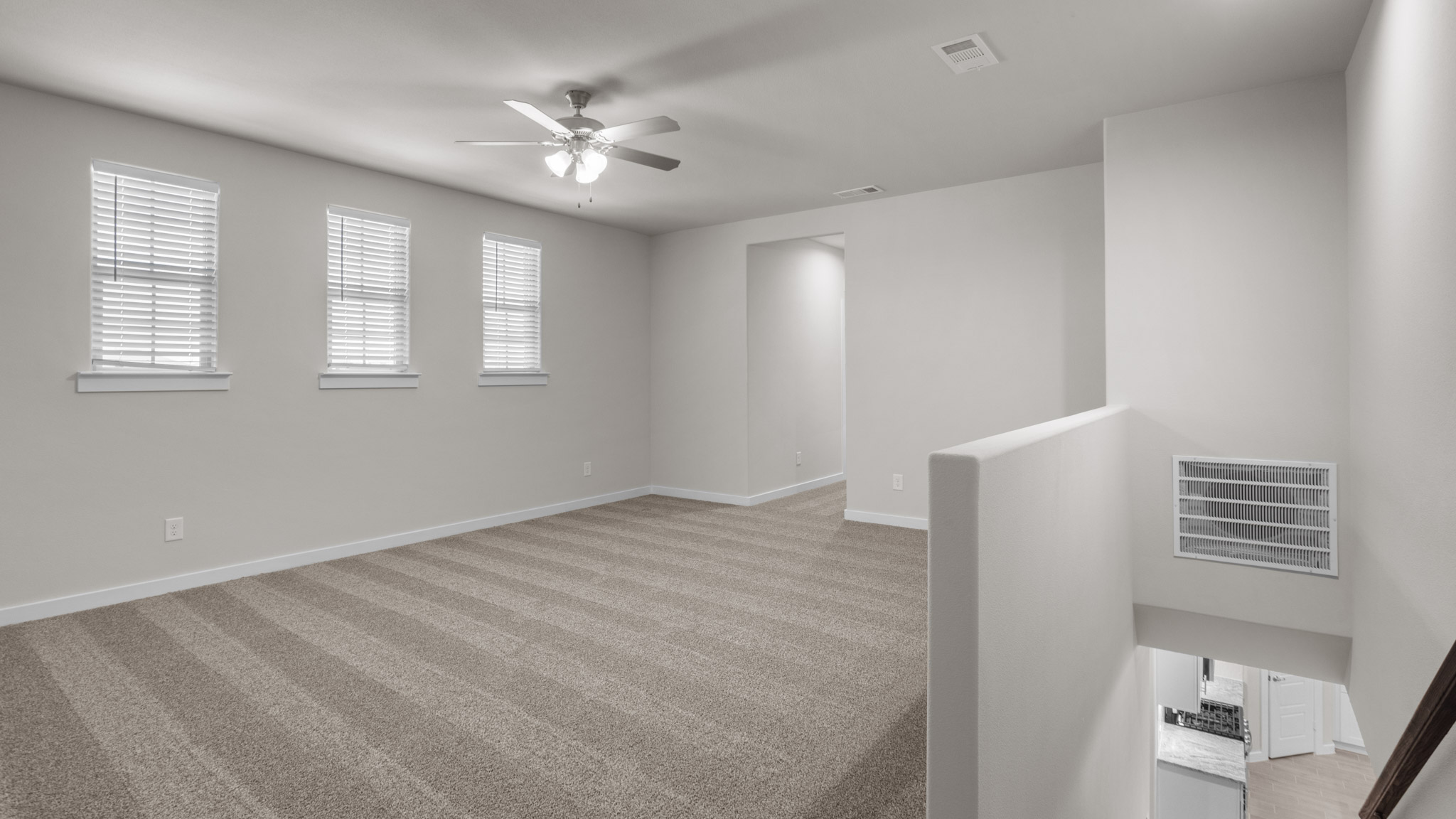 Upstairs landing area with ample natural light and plush carpet floors