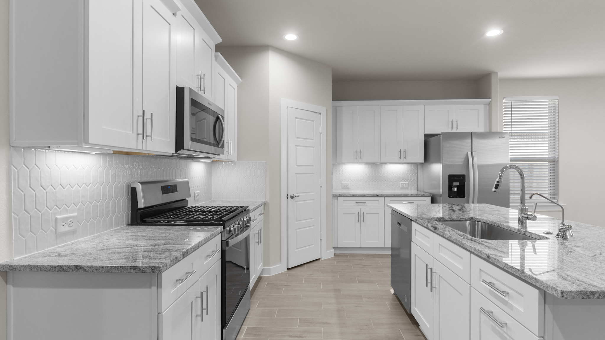 Spacious kitchen complete with stylish backsplash and stainless steel appliances