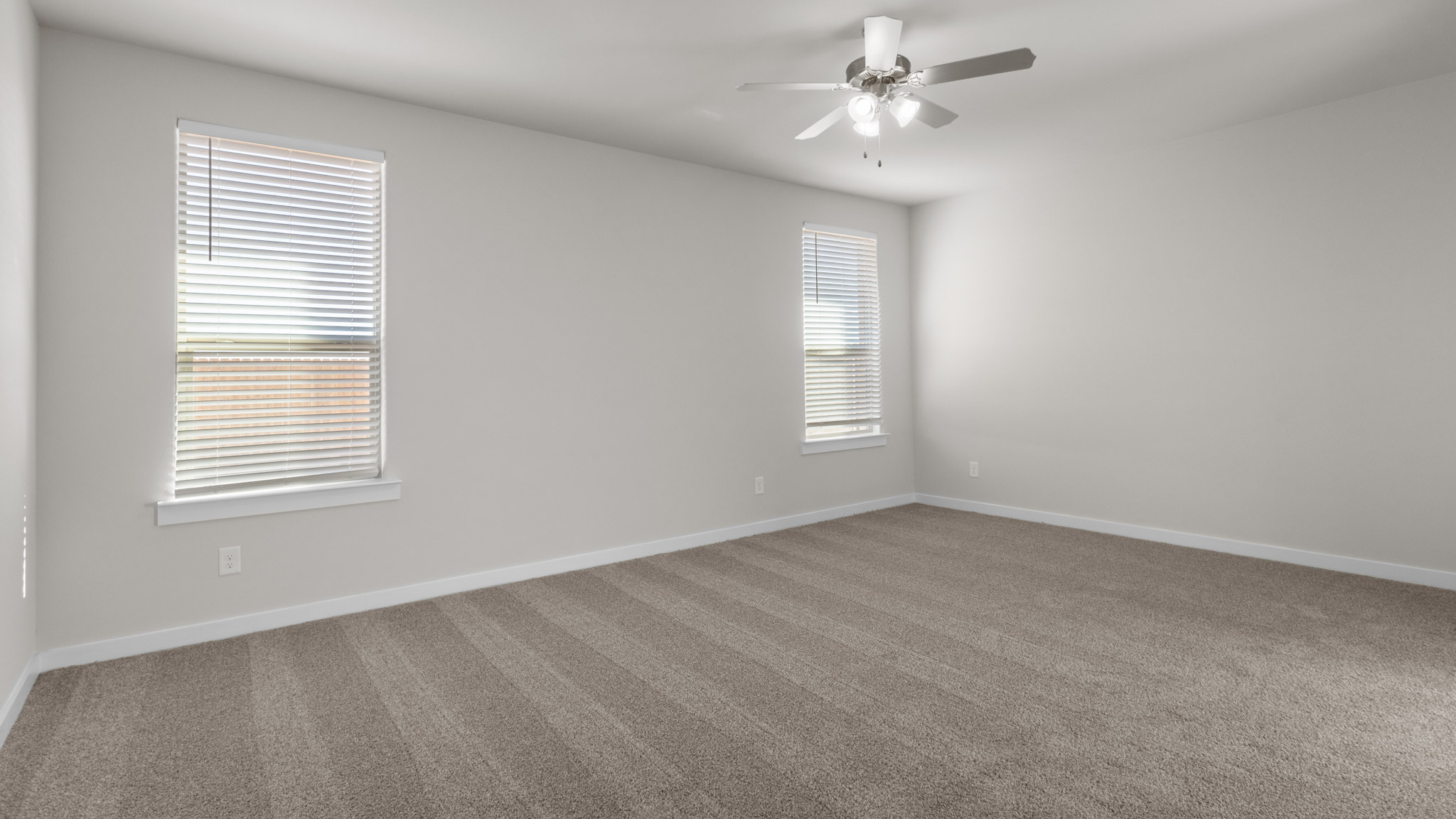 Primary bedroom with plush carpet floors and ample natural light