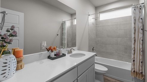 Guest bathroom with tiled bathtub and shower space and built in vanity