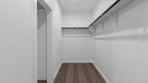 Primary walk-in closet attached to primary bathroom and bedroom