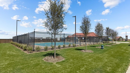 Fenced in shared community area with swimming pool, clubhouse, and green landscaping