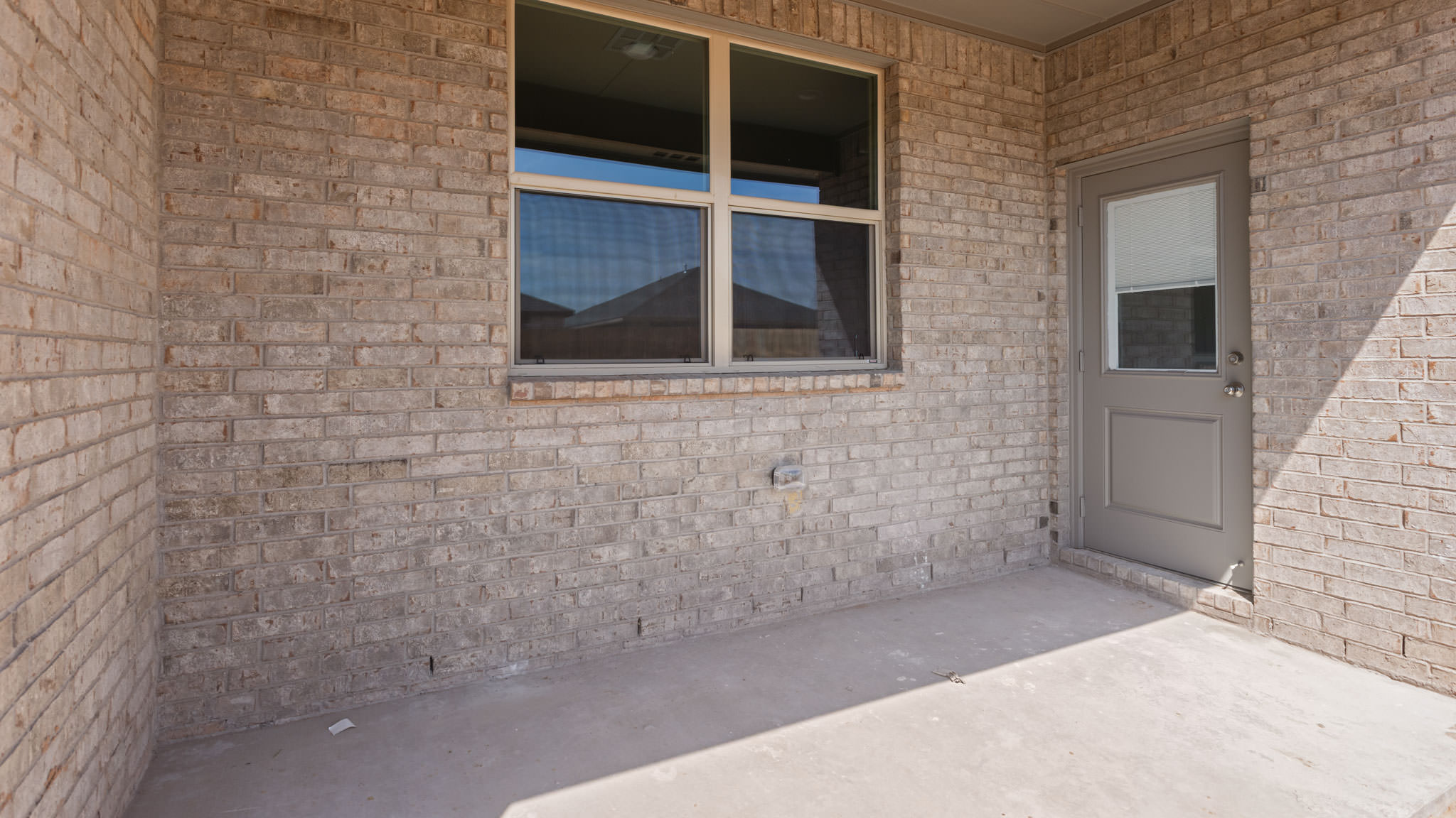 Covered back patio area overlooking spacious backyard
