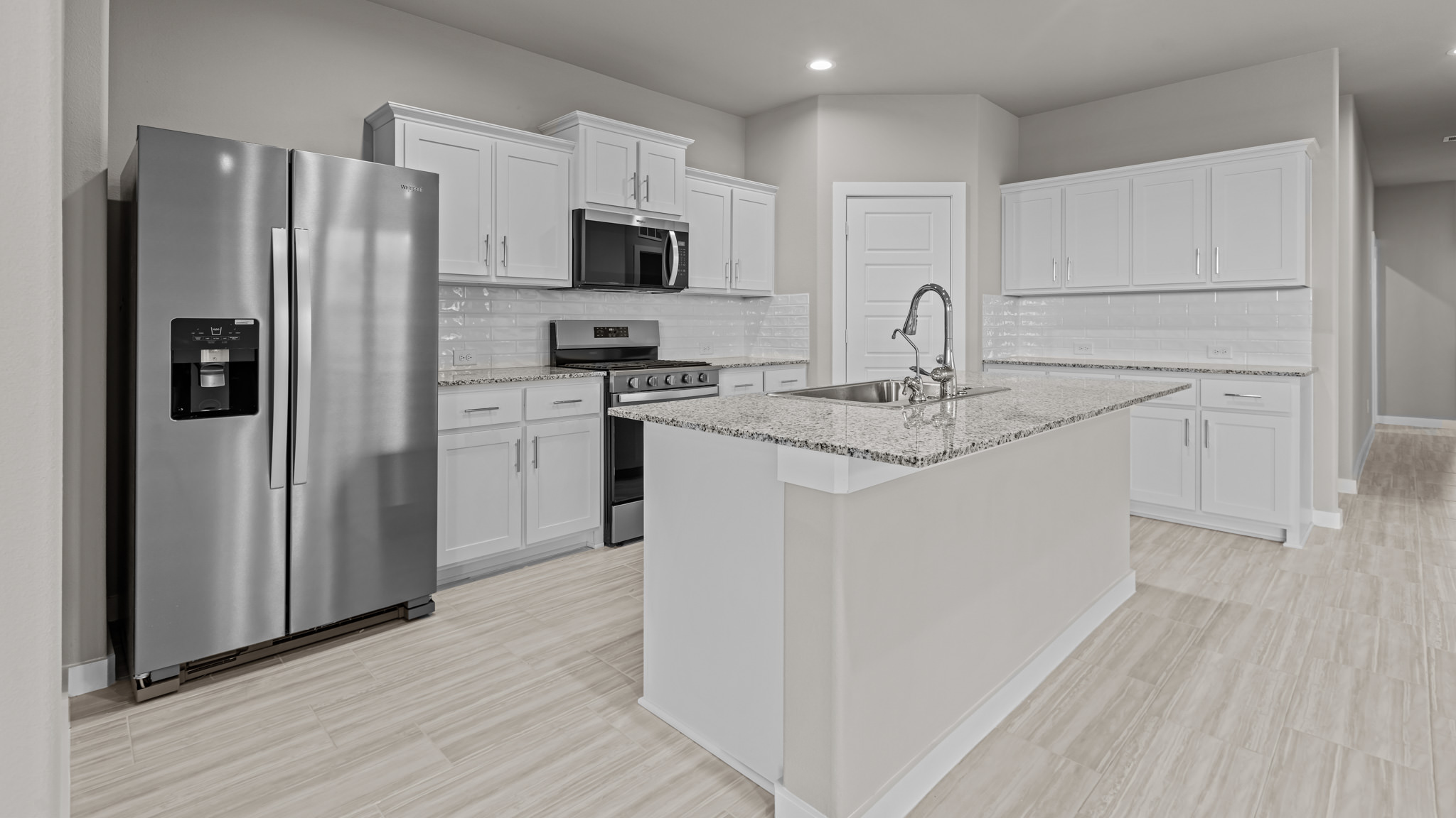 Open concept kitchen with stainless steel appliances, shaker style cabinets, and elevated finishes