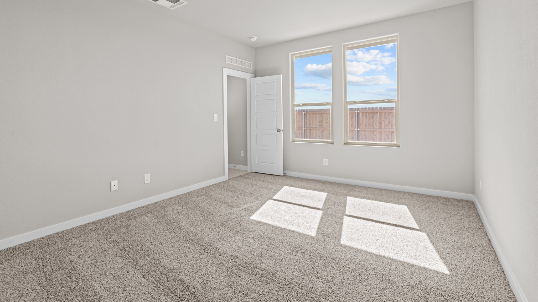 Primary bedroom with plush carpet floors and light allowing double windows