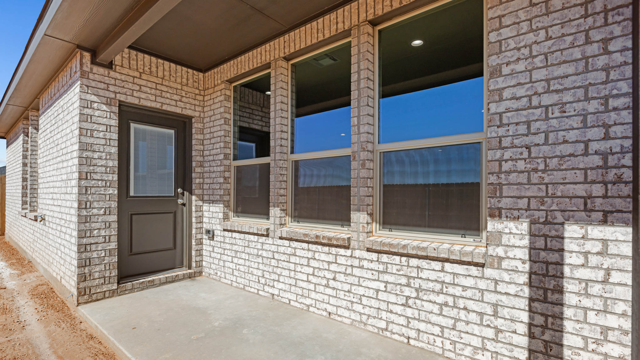 Covered back patio area overlooking spacious backyard