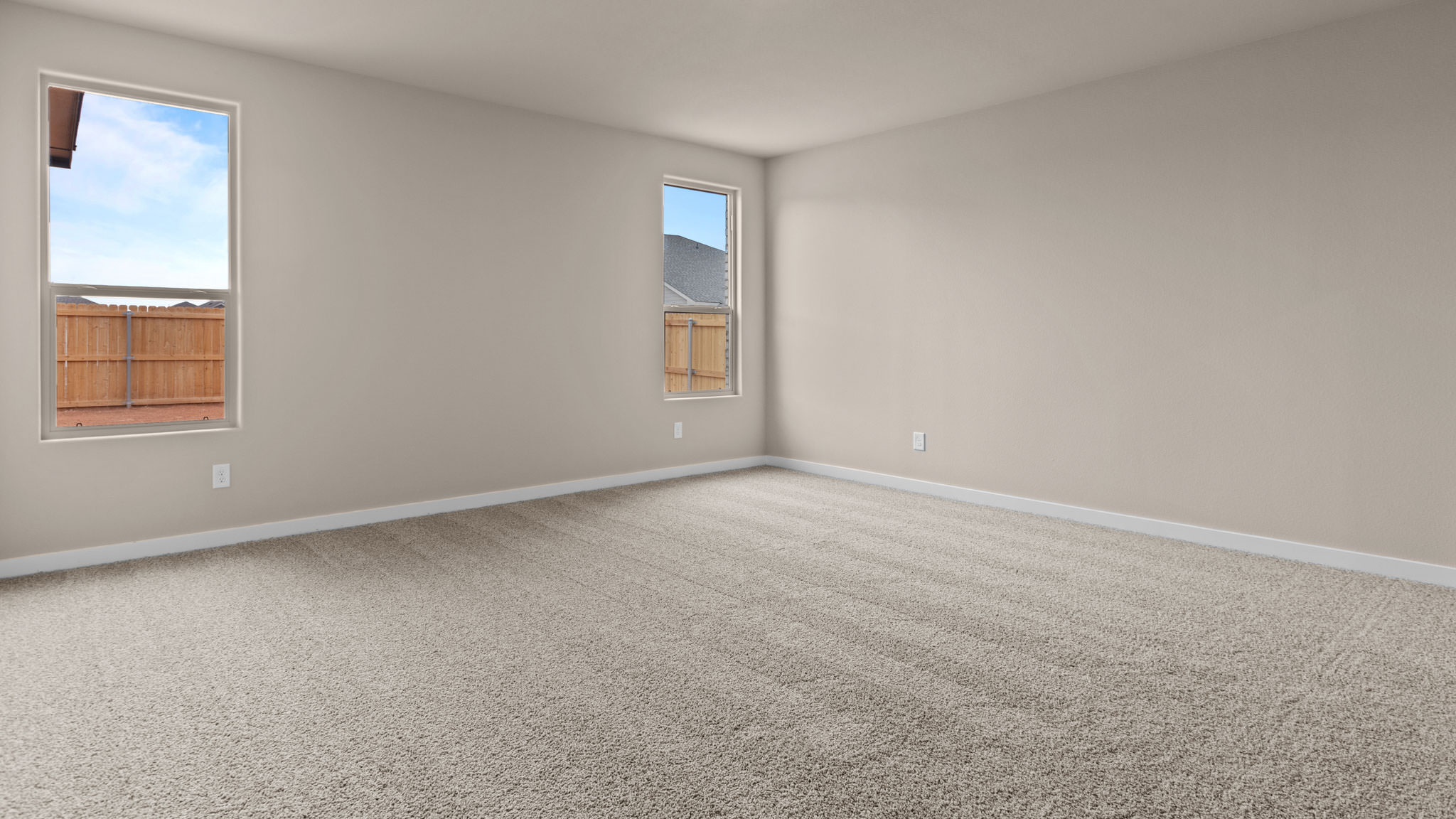 Primary bedroom with plush carpet floors and double light allowing windows