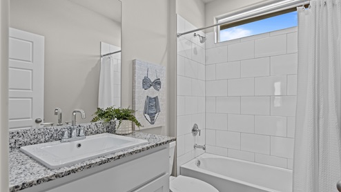 Guest bathroom with elevated tile dual bathtub and shower combination