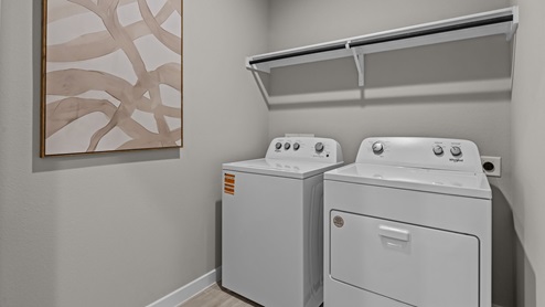 Laundry room and utility closet area with built-in shelving and hanging rack space