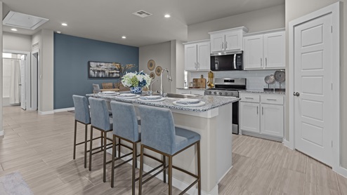 Open kitchen with spacious island sitting area and designated dining space to the side