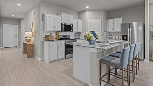 Open concept modern light kitchen with ample natural light and beautiful light blue and gold accents
