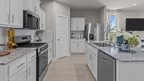 Open kitchen with stylish backsplash, stainless-steel appliances, granite countertops, and shaker style cabinets
