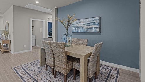 Open dining space to the side of kitchen featuring a cool blue accent wall